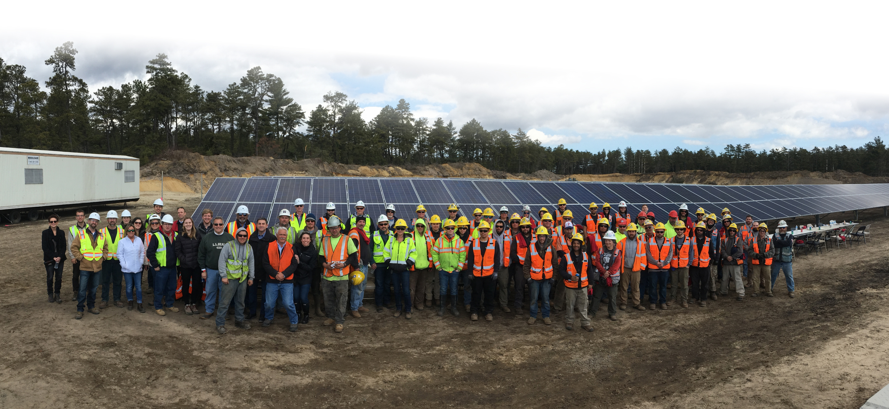 Construction team in front of solar panels.
